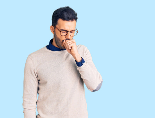 A man coughing into his hand