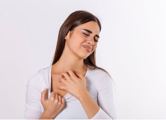 A woman touching irritated skin on her neck and chest