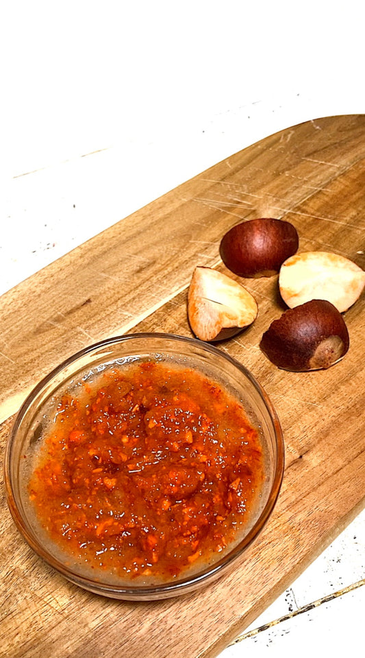 Mashed avocado face mask in a small bowl with a halved avocado