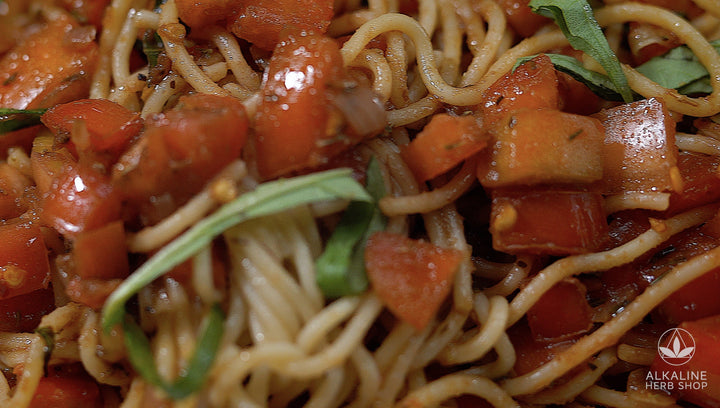 Close up of spaghetti noodles, tomatoes, basil