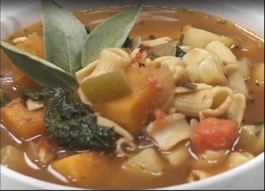 Bowl of hearty vegetable soup with kale and chopped vegetables